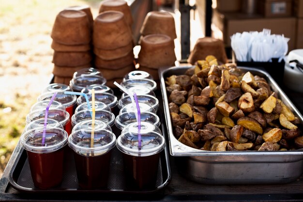 Delicious baked potatoes and cups with juice