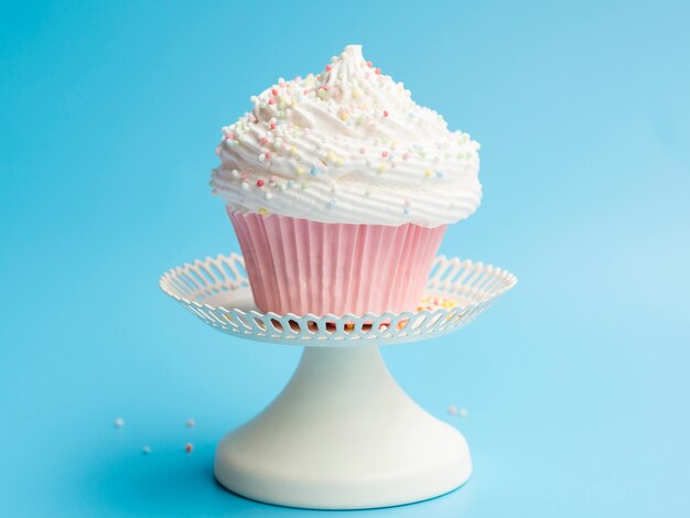 Delicious birthday muffin on blue background