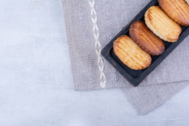 Delicious biscuits on black plate with tablecloth.