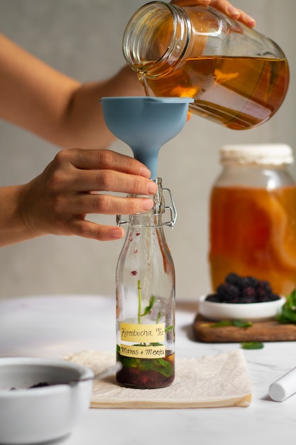 Free photo delicious blackberries kombucha bottle still life