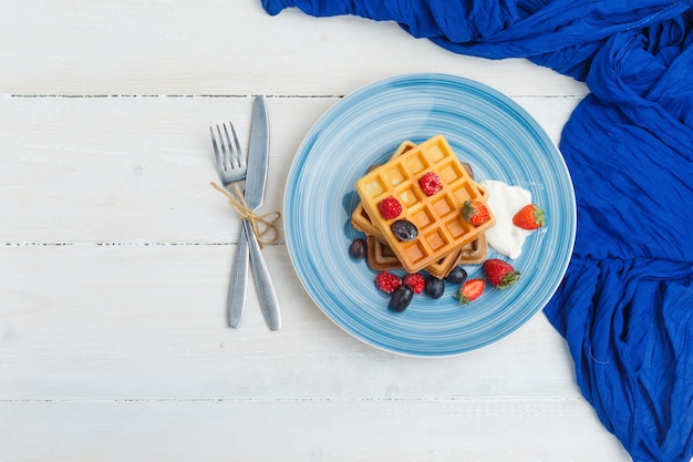 Delicious breakfast with waffles and fruits