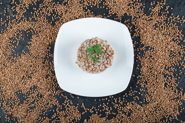 Free photo delicious buckwheat with greens on white plate.