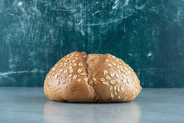 Delicious bun with seeds on marble.