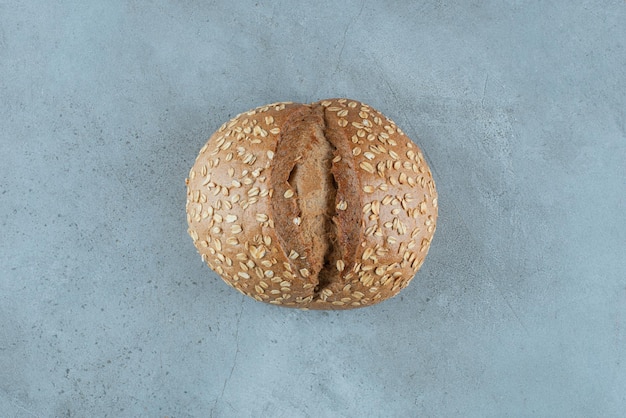 Delicious bun with seeds on marble.