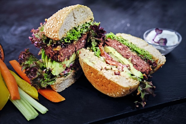 Delicious burger, fries with salad on a table.