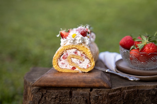 Delicious cake with strawberries outdoors