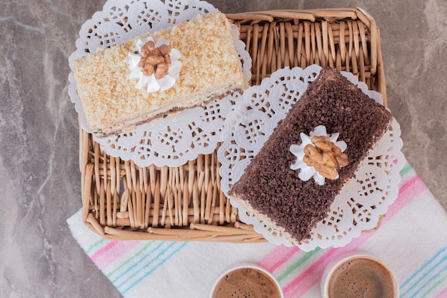 Delicious cakes and cups of coffees on tablecloth.