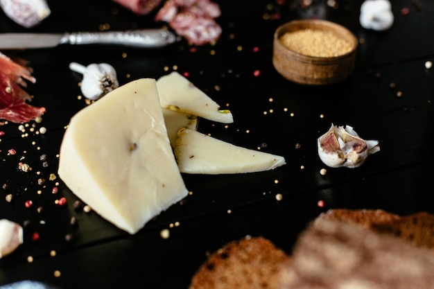 Delicious cheese with festashkami on black wooden table