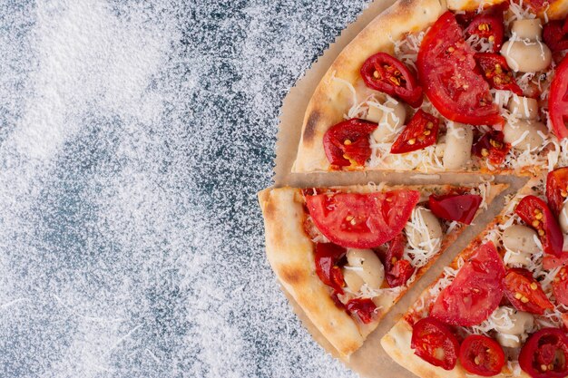 Delicious chicken pizza with tomatoes on marble. 