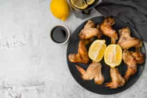 Free photo delicious chicken wings coffee and lemons