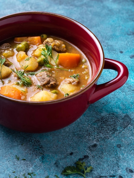 Delicious chickpea and potato curry with beef in a red saucepan