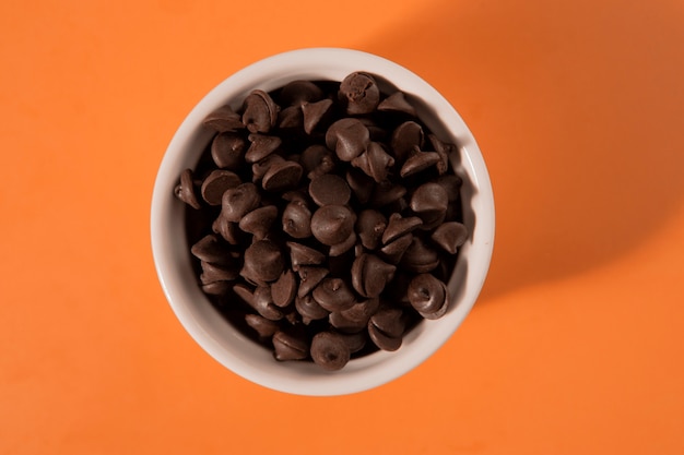 Delicious chocolate chips in bowl top view