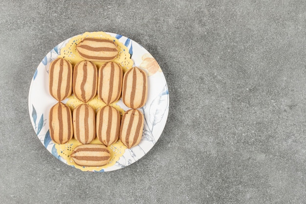 Delicious chocolate striped biscuits on colorful plate