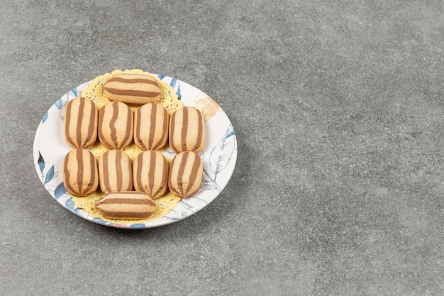 Delicious chocolate striped biscuits on colorful plate