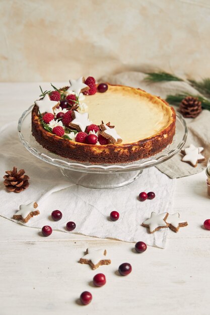 Delicious Christmas cheesecake with cranberries and cookies stars on a white table