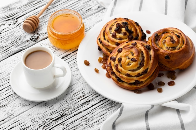 Free photo delicious cinnamon raisins rolls on wooden table