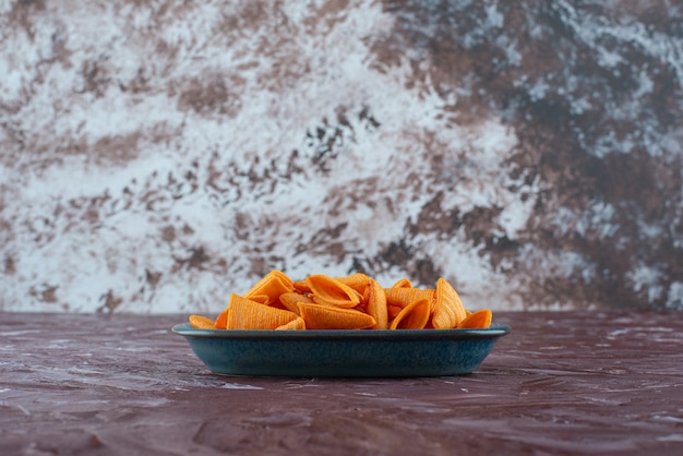 Delicious cone chips in a plate on the marble surface