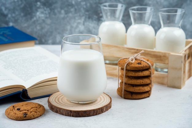 Delicious cookies with glass of milk and book.