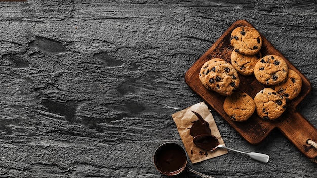 Delicious cookies on wooden board with chocolate