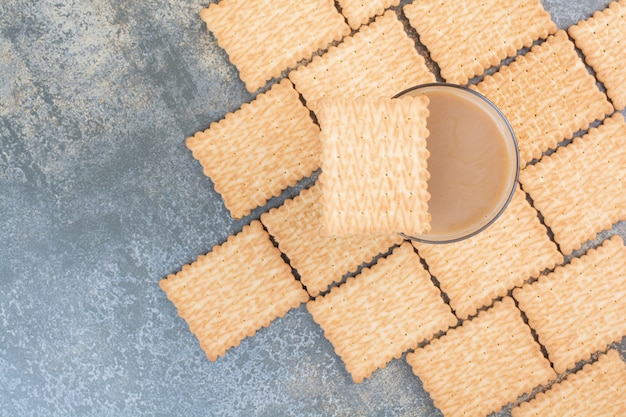 Delicious crackers with cup of coffee on marble background. High quality photo