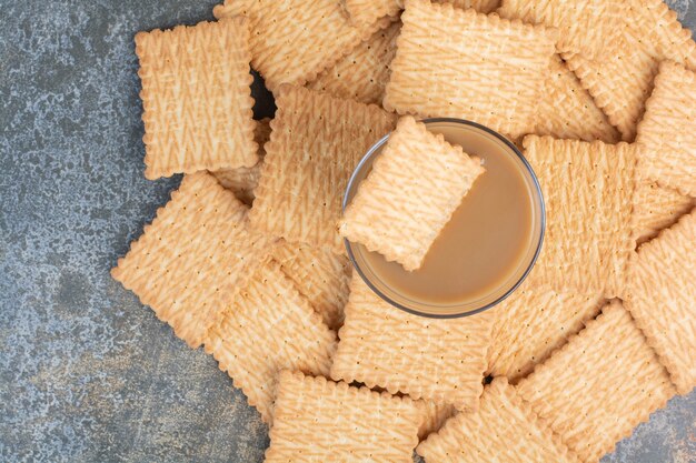 Delicious crackers with cup of coffee on marble background. High quality photo