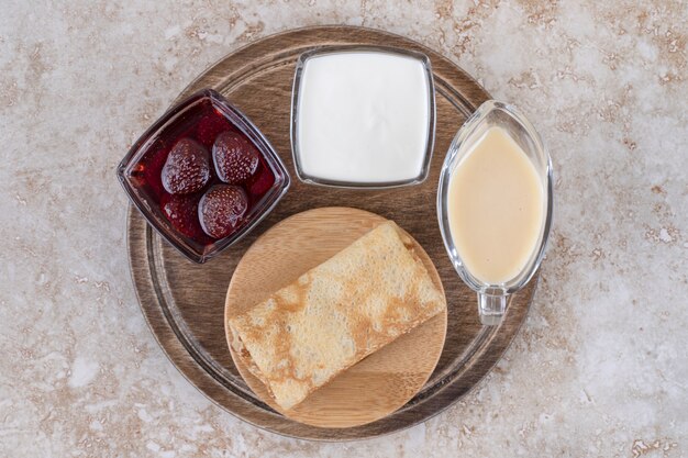 Delicious crepes with sour cream and strawberry jam