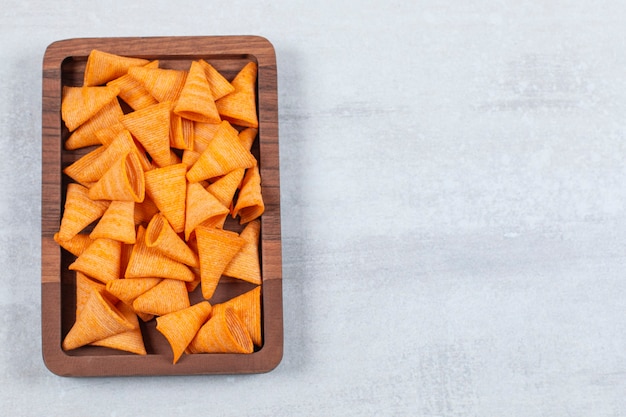 Free Photo delicious crunchy chips on wooden plate.