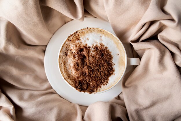 Delicious cup of coffee with cocoa powder