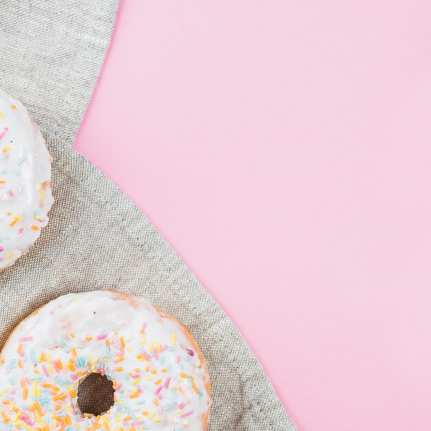 Delicious doughnuts with icing on gray cloth