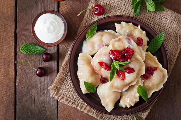 Free photo delicious dumplings with cherries and jam