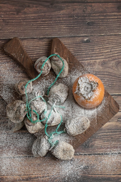 Free photo delicious fresh and dried persimmon fruits on wooden board