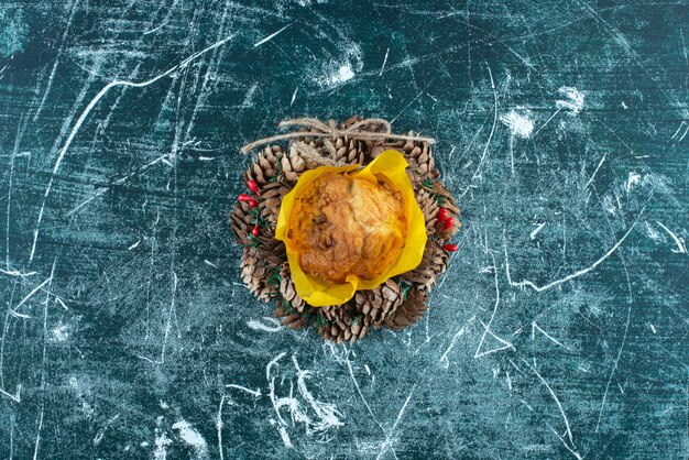 Delicious fresh muffin and Christmas wreath on a colorful background. High quality photo