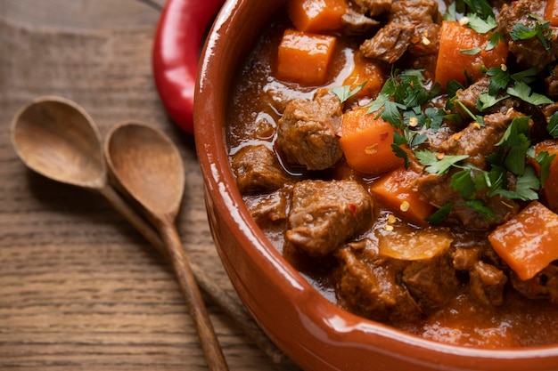 Delicious goulash stew on table