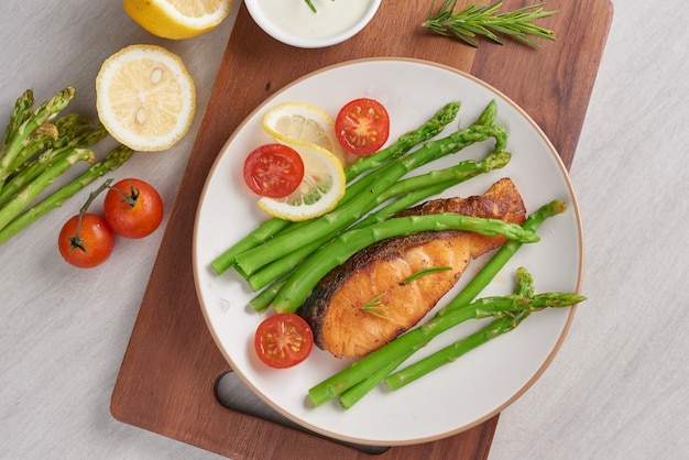 Delicious green asparagus and sliced smoked salmon on a rustic plate