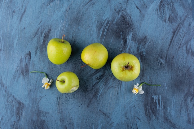 Free photo delicious green fresh apples placed on blue table.