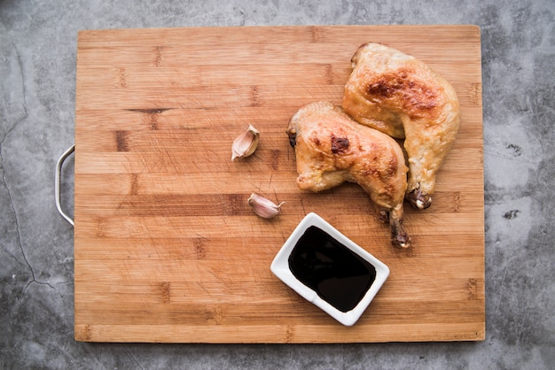 Free photo delicious grilled chicken legs with soy sauce and garlic on cutting board