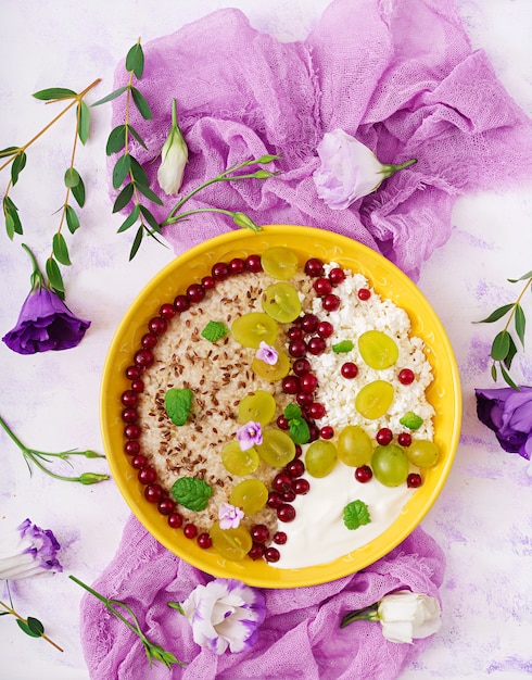 Delicious and healthy oatmeal with grapes, yogurt and cottage cheese. Healthy breakfast. Fitness food. Proper nutrition. Flat lay. Top view.