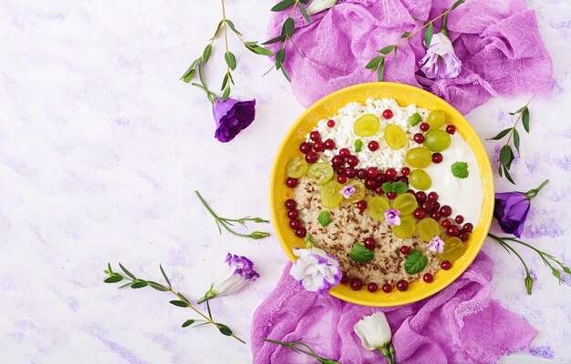 Free Photo delicious and healthy oatmeal with grapes, yogurt and cottage cheese. healthy breakfast. fitness food. proper nutrition. flat lay. top view.