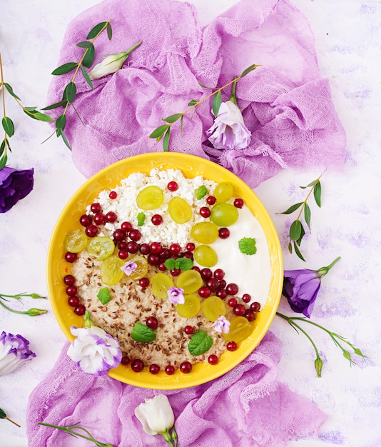 Free Photo delicious and healthy oatmeal with grapes, yogurt and cottage cheese. healthy breakfast. fitness food. proper nutrition. flat lay. top view.