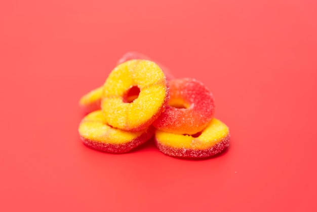 Delicious jelly fruits on red background