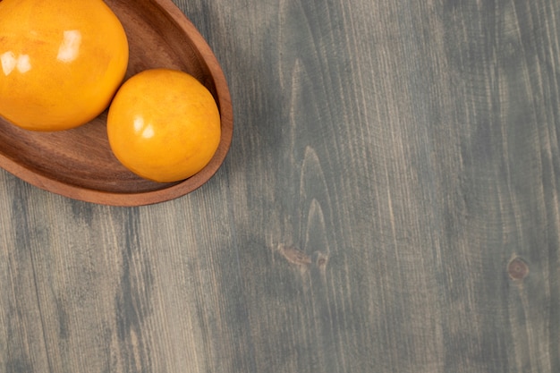 Free Photo delicious juicy persimmons on a wooden board. high quality photo