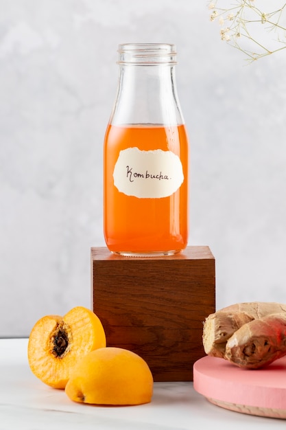 Free photo delicious kombucha bottle and peach