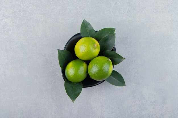 Delicious lime fruits in black bowl