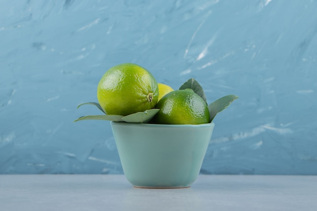 Free Photo delicious lime fruits in blue bowl. 