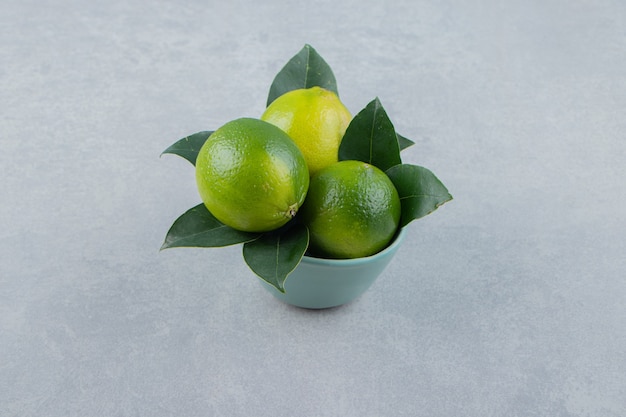 Delicious lime fruits in blue bowl