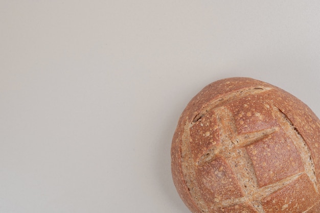 Delicious loaf of bread on white surface