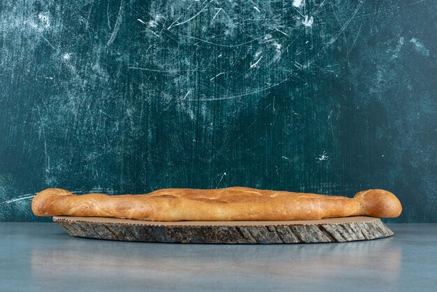 Delicious loaf of bread on wooden piece.