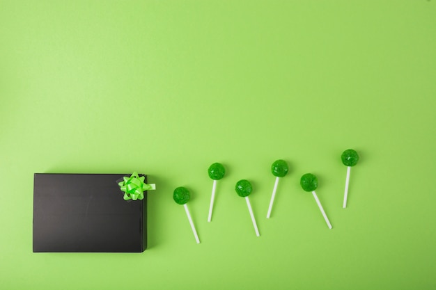 Delicious lollipop with black box over the green background