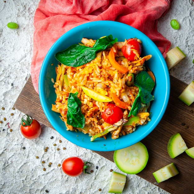 Free photo delicious meal in a blue plate on a wood, red cloth and white textured background. top view.