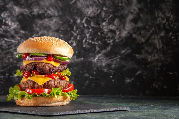 Free photo delicious meat sandwich with tomatoes green on dark color tray on the right side on black surface